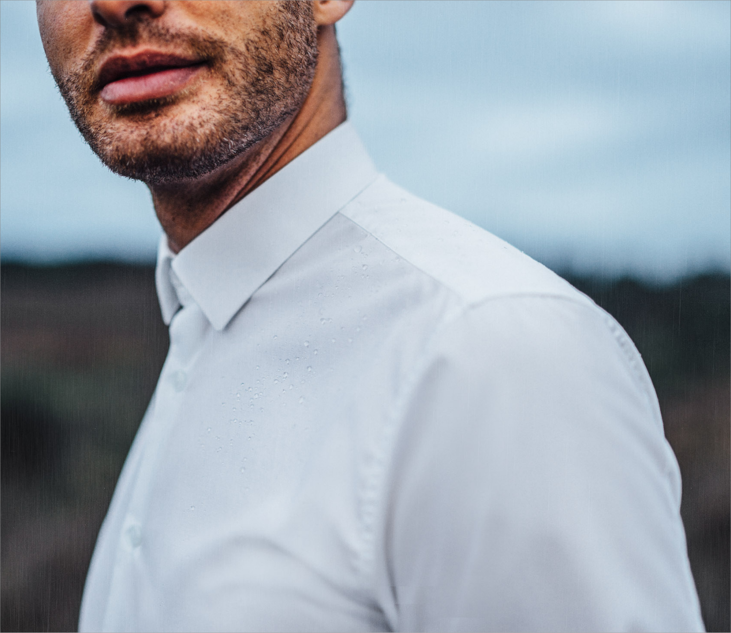 Zoomed-in picture of a mans shoulder, wearing a white shirt.